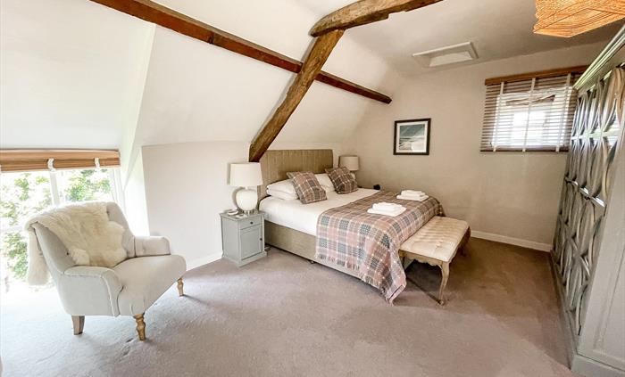 Superking master bedroom at self catering holiday let ysgubor degwm in north wales. Wesh tapestry blanket in pale pinks and blues on the bed